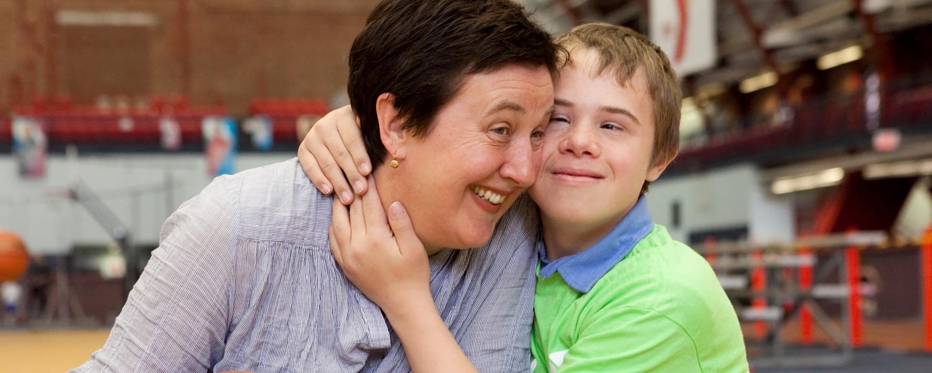 YMCA. Child and teacher hug.